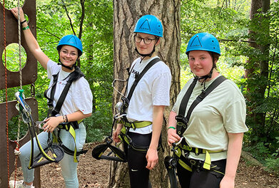 Lehrlinge im Klettergurt beim Outdoorevent