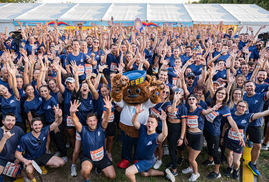 Gruppenbild mit HOFER Mitarbeiter:innen und HOFER Bär am Vienna Business Run
