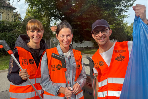 drei Mitarbeiter:innen beim Müllsammeln