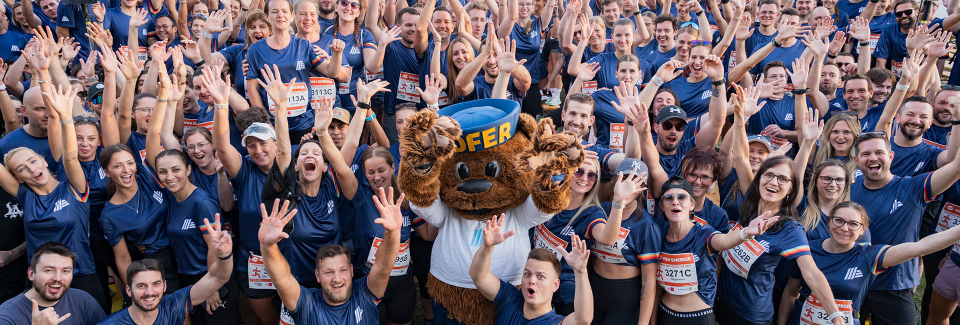Gruppenbild mit HOFER Mitarbeiter:innen und HOFER Bär am Vienna Business Run