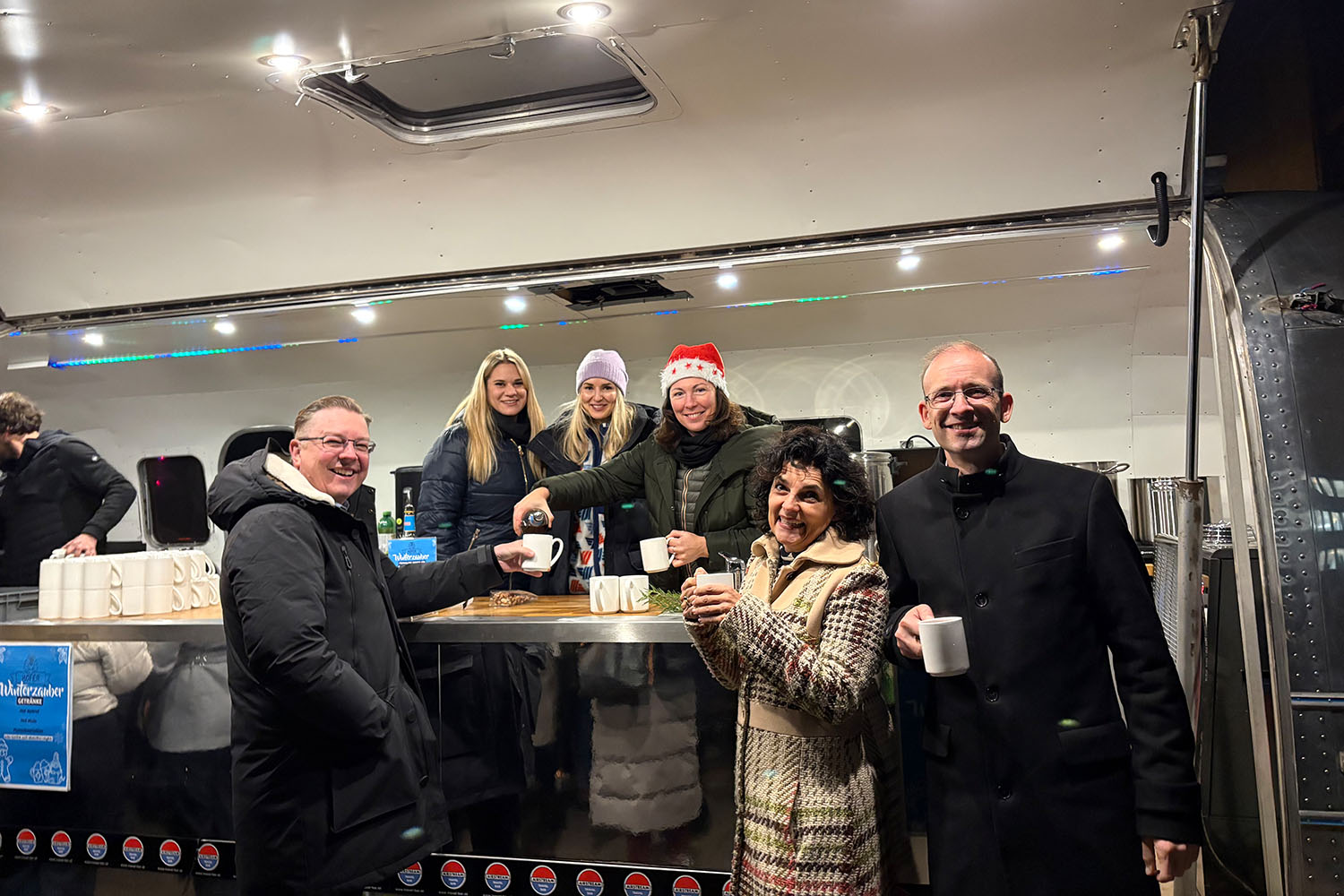 Führungskräfte und Eva Posan bei der Arbeit im Punschstand