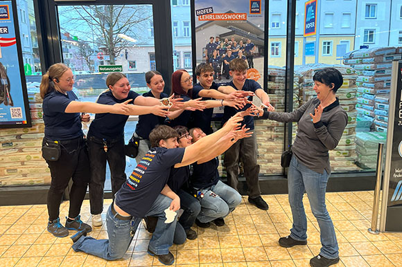 Gruppe von Lehrlinge schnappen sich Schlüssel von Filialleiterin