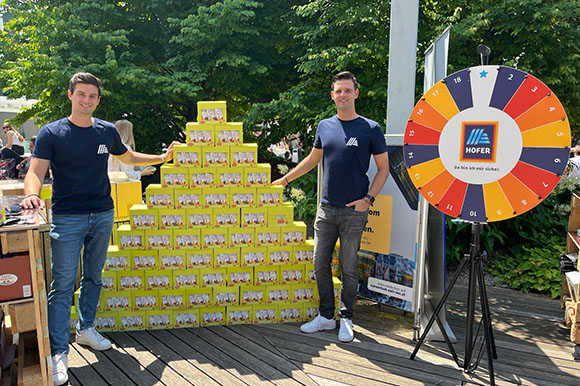 Mitarbeiter mit HOFER Glücksrad am WU-Sommerfest