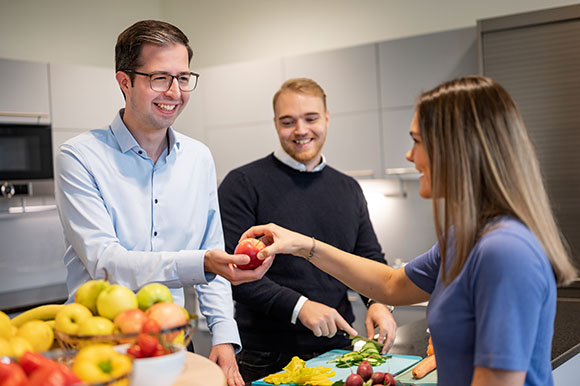 Mitarbeiter:innen bei der Zubereitung einer Mahlzeit