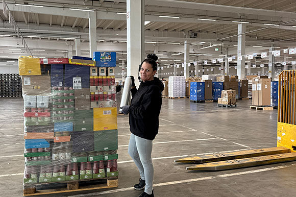 Lagermitarbeiterin Irene beim Umwickeln der kommissionierten Palette