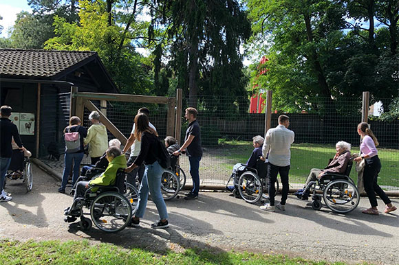 Mitarbeiter:innen mit älteren Personen im Zoo