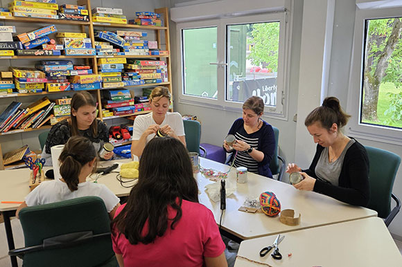 Vier Mitarbeiterinnen beim Basteln mit Kindern