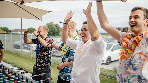 Foto von freudigen HOFER Mitarbeiter beim Tischfußball spielen 