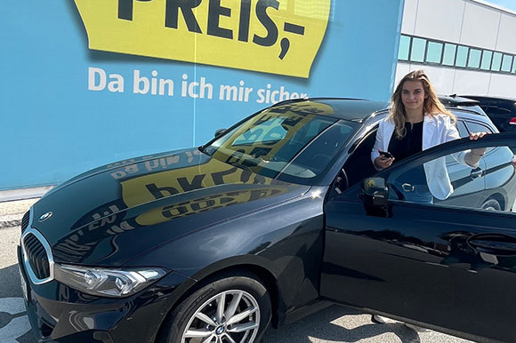 Managementpraktikantin Josepha mit ihrem Firmenwagen der Marke BMW