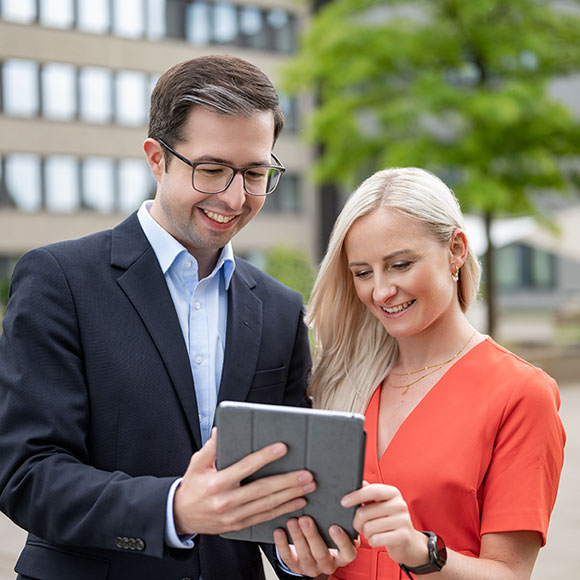 zwei Mitarbeiter, die gemeinsam am Tablet arbeiten