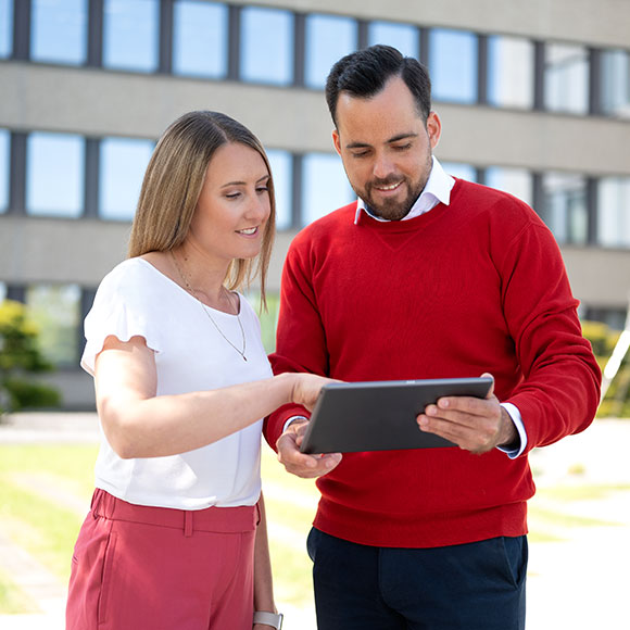 zwei Mitarbeiter, die gemeinsam am Tablet arbeiten