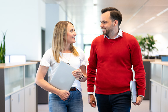 zwei Personen am Weg zu ihrem Arbeitsplatz im Büro
