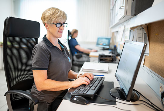 Filialleitung sitzt im Büro vor dem PC